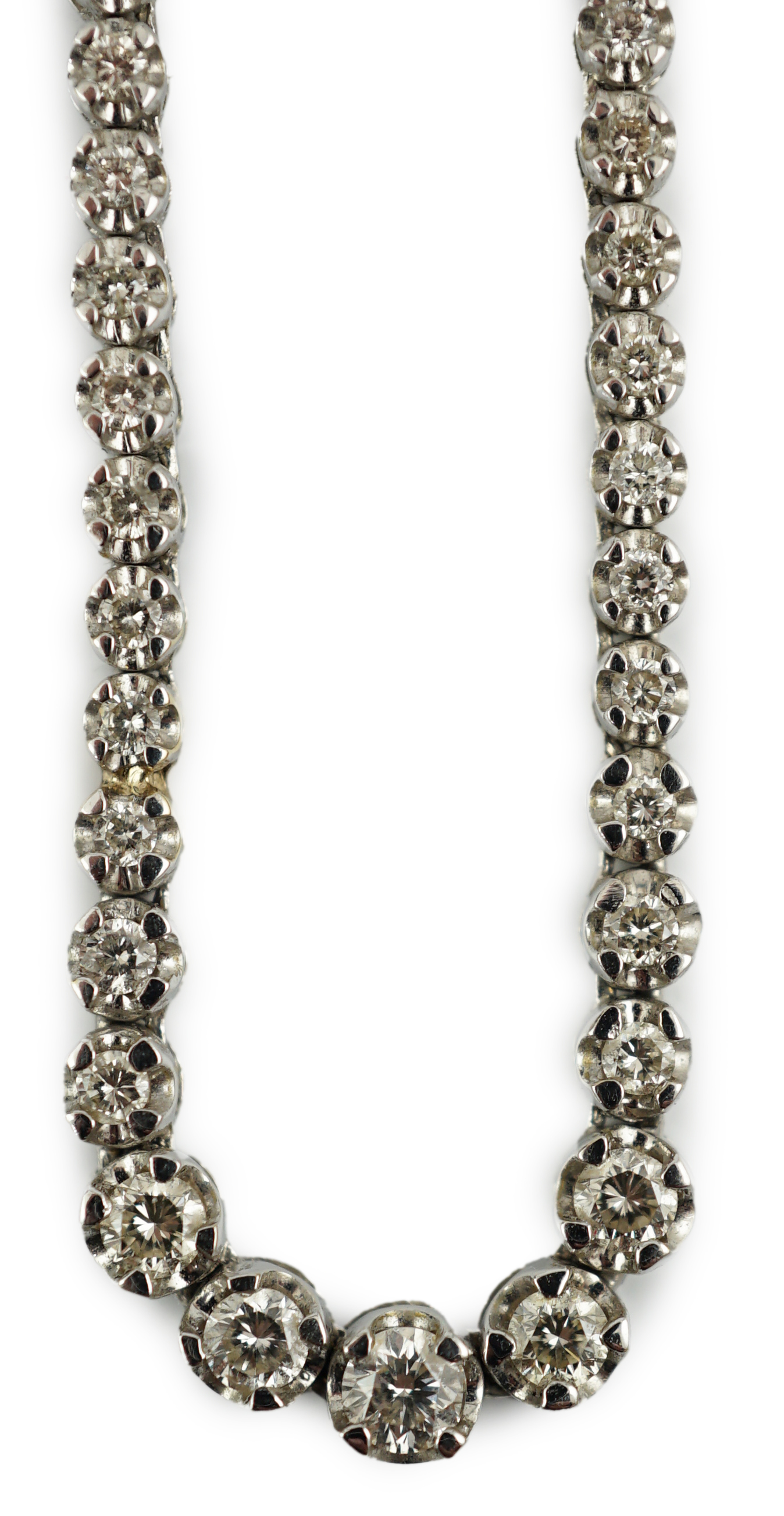 A modern 18k gold and illusion set diamond line necklace, set with diamond chips and five graduated larger stones, 40cm, gross weight 17 grams. Condition - poor to fair (old repair to one link)